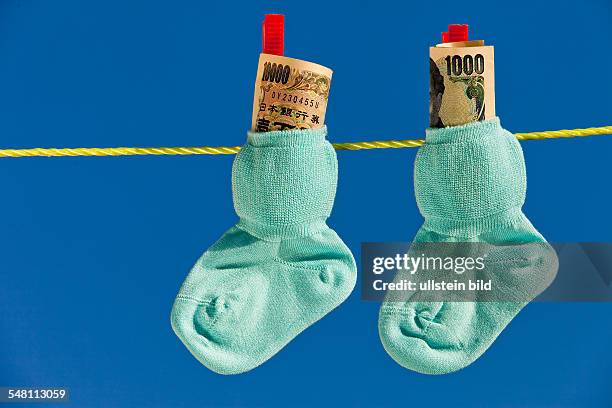 Baby socks with Japanese Yen banknotes on the clothesline