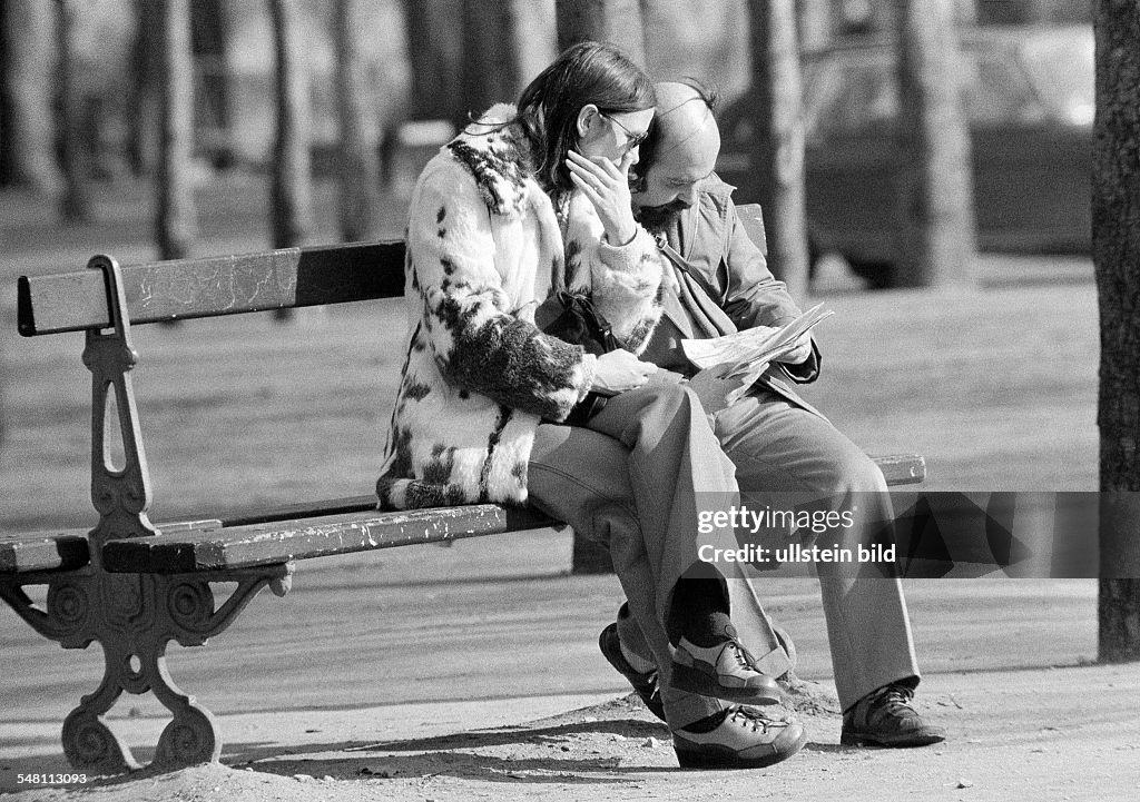 People, couple sits on a bench viewing a road map, aged 30 to 40 years, France, Paris - 09.02.1975