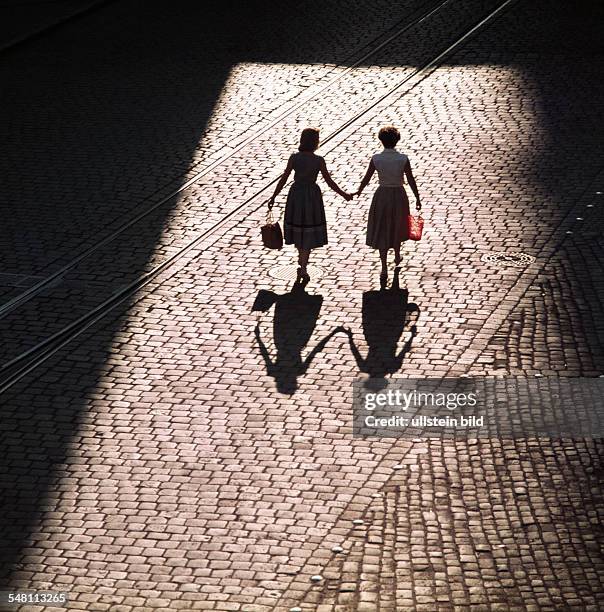 Germany - Bavaria - Regensburg: two woman walking hand in hand -
