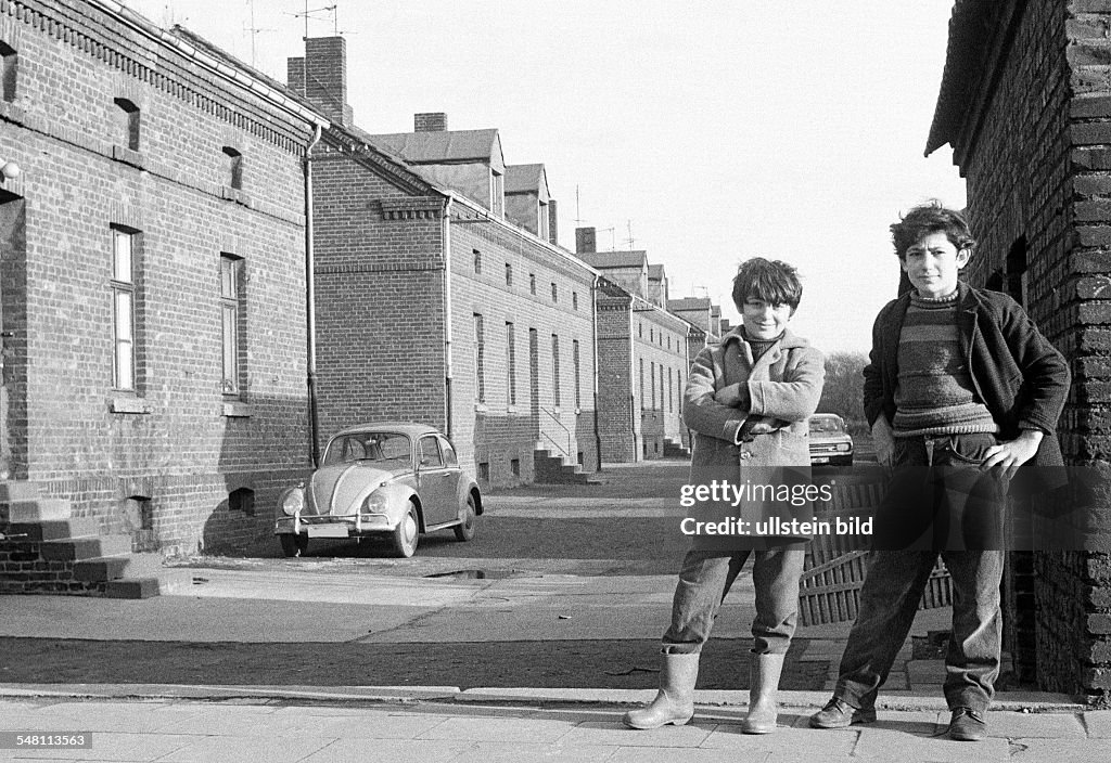 People, children, two boys posing at a housing estate, pithead buildings, colony Eisenheim, in front of a house stands a car, VW, Volkswagen, Beetle, Turks, aged 10 to 15 years, D-Oberhausen, D-Oberhausen-Eisenheim, Ruhr area, North Rhine-Westphalia 