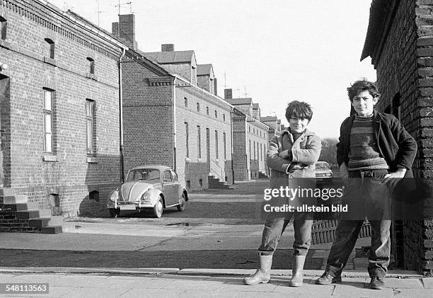 People, children, two boys posing at a housing estate, pithead buildings, colony Eisenheim, in front of a house stands a car, VW, Volkswagen, Beetle,...