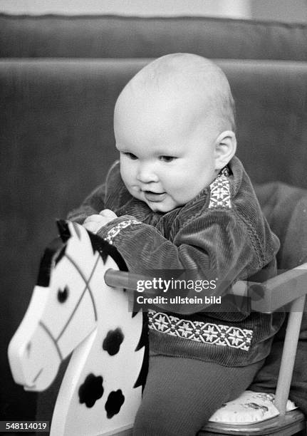 People, children, baby sits on a rockinghorse, laughing, aged 6 to 12 months, aged 1 year, Christina -