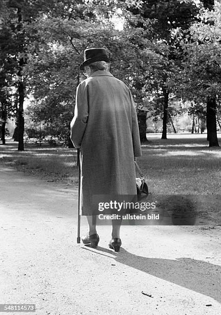 People, senior, older woman walks through the park, walking stick, coat, hat, aged 70 to 80 years -