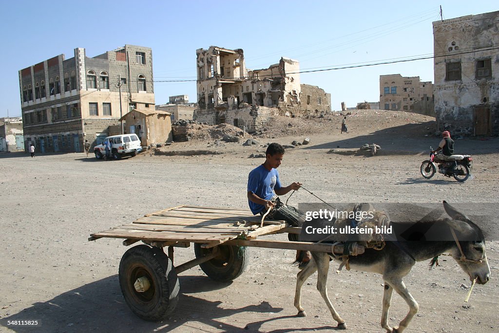 Yemen Al-Mukha, Mocha, Mokka, Mokha - boy on a donkey-cart in front of ruins of houses