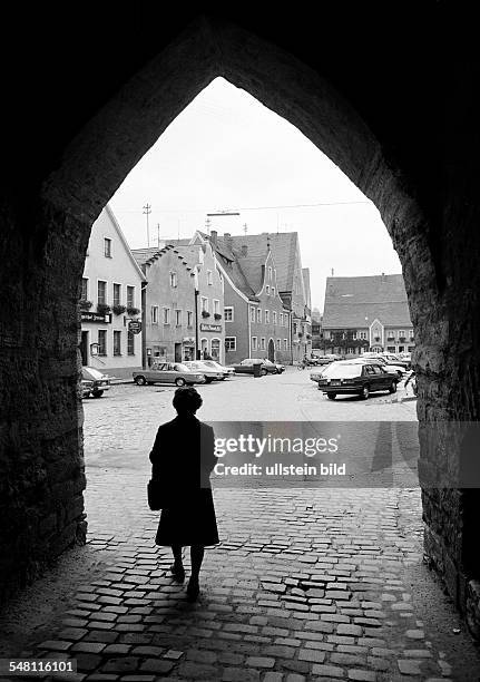 People, elder woman walks through a town gate to the market place, residential buildings, backlight, silhouette, aged 65 to 75 years, D-Berching,...