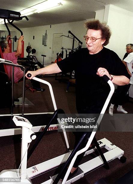 Ältere Frau trainiert im Fitness-Studio an einem Lauftrainer im Sportzentrum Oranienburg - 1997