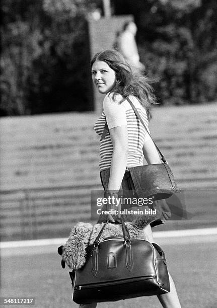 People, young girl with a handbag and a shopping bag look back to the camera, aged 18 to 22 years -