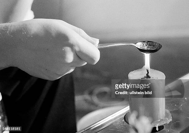 People, night of New Years Eve, celebrating New Years, symbolic, soothsay, lead-pouring, hand holds a spoon containing plumb over a lighted candle -