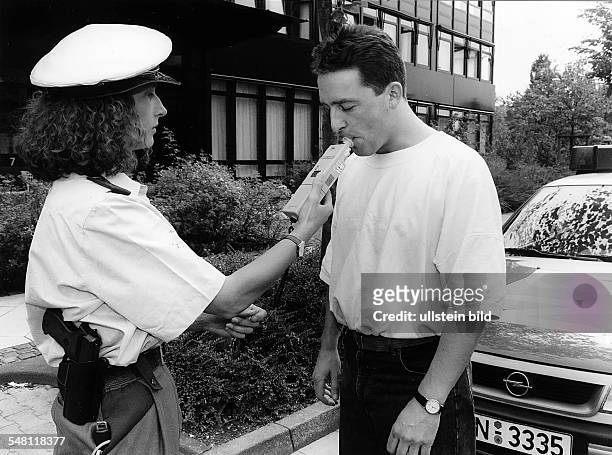 Polizistin beim Abnehmen einer Alkoholprobe. - 00.07.1994