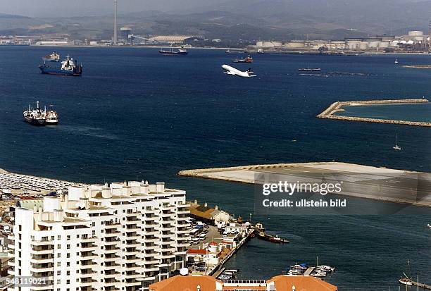 Blick auf einen Teil der Landebahn im Meer und ein startendes Passagierflugzeug - 1997