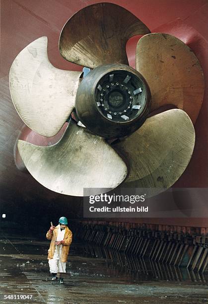 Schiffsschraube der "Queen Elisabeth II" auf der Werft Blohm & Voss darunter: Werftarbeiter mit Schrubber - 1994