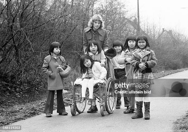 People, physical handicap, refugees, childrens nurse and six girls from Vietnam, one girl sits in a wheel-chair, aged 16 to 20 years, aged 4 to 12...
