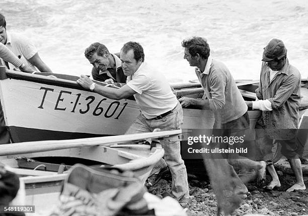 Several fishermen in the fishing port of Puerto de la Cruz pull a fishing boat ashore, aged 40 to 60 years, Spain, Canary Islands, Canaries, Tenerife...