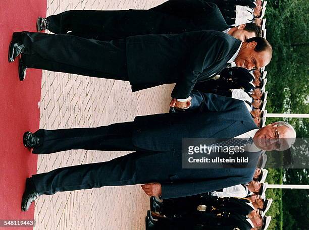 Silvio Berlusconi, Ministerpräsident von Italien, und der deutsche Bundeskanzler Helmut Kohl lachend auf dem roten Teppich vor einer Ehrenformation...