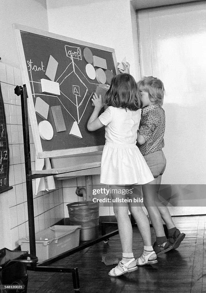 Edification, school, schoolboys and schoolgirls in a school class during lessons, children aged 7 to 10 years, boy and girl at a blackboard - 31.08.1973