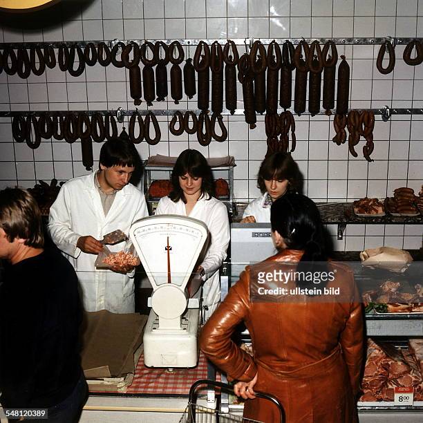 Fleisch- und Wurstverkauf: Kunden an der Theke, Verkäufer beim Auswiegen und Kassieren - 1984