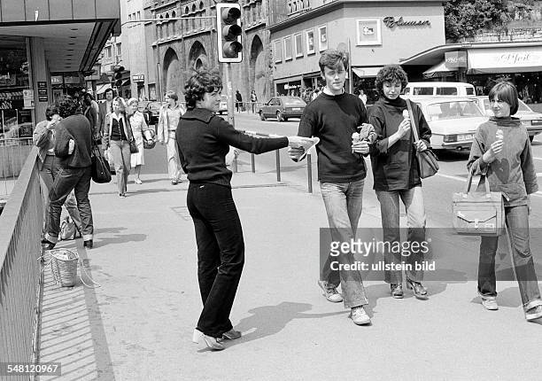 People, opinion-forming, advertising, young woman handing out flyers to passersby walking on a pavement, D-Tuebingen, Neckar, Steinlach, Ammer,...