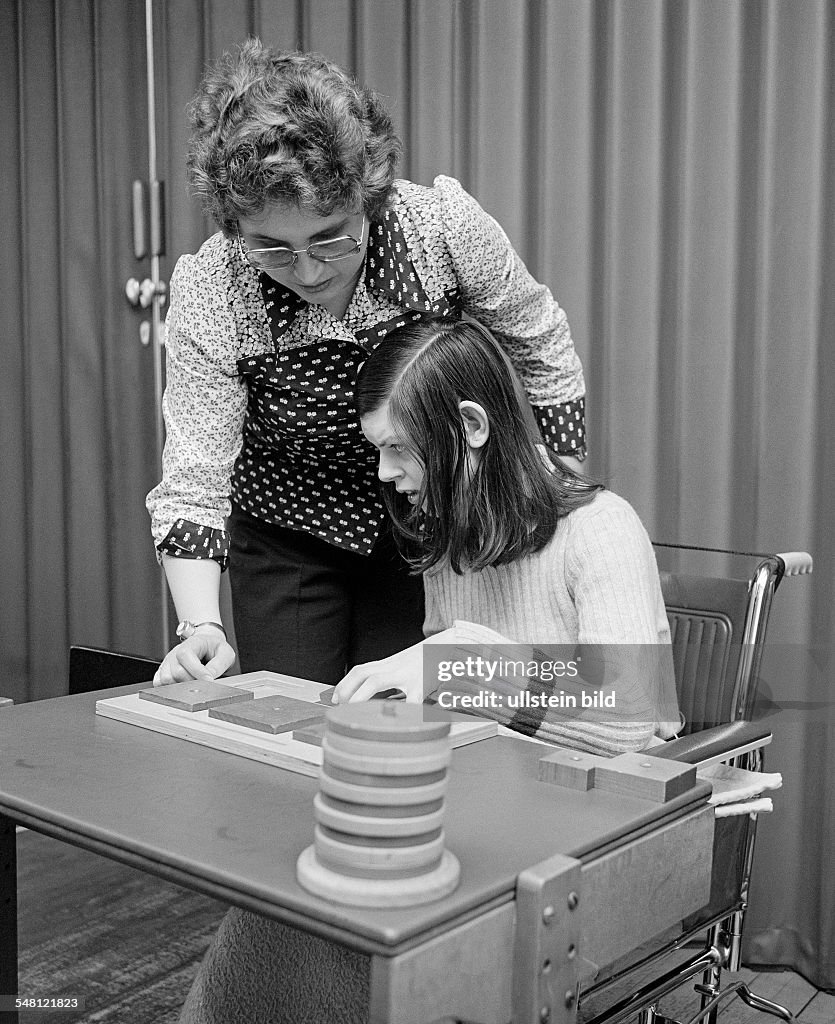 People, physical handicap, school lessons, teacher assists a girl sitting in a wheel-chair in the exercises, aged 30 to 40 years, aged 12 to 16 years, Special School Alsbachtal, D-Oberhausen, D-Oberhausen-Sterkrade, Ruhr area, North Rhine-Westphalia 