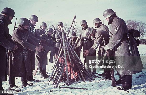 World War II German soldiers at the Eastern Front warming themselves at a fire - no place given - winter 1941/42 - Photographer: Artur Grimm -