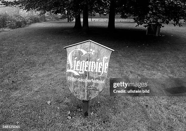 Meadow is released as lawn for sunbathing by a signboard asking to keep clean the lawn -