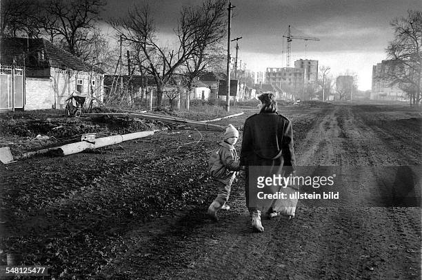 Strassenzene in Grosny Mutter mit ihrem Sohn auf einer Vorortstrasse - 1996