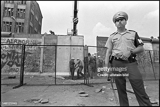 Germany, Berlin, , Bomb attack on the Berlin wall at Zimmerstrasse in the district of Kreuzberg. GDR border soldiers and members of US Army Military...