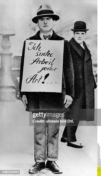 Germany, great depression 1929-32 An unemployed in a street in Berlin wearing a poster "I?m seeking work of any kind!" - 1932