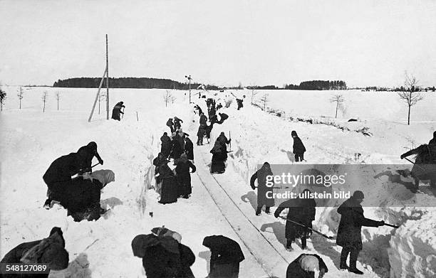 Osten: Zivilisten sind zum Freischaufeln der zugeschneiten Strecke einer Feldeisenbahn herangezogen. Im Baltikum / Januar/Februar 1916