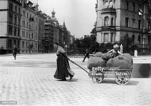Germany Kingdom Bavaria Munich: Female ragpicker pulling a cart - 1911 - Photographer: Philipp Kester - Vintage property of ullstein bild