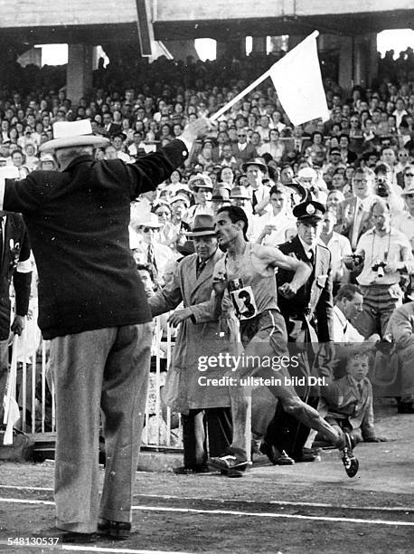 Marathon: - Olympiasieger Alain Mimoun läuft in das Olympiastadion ein. Dezember 1956