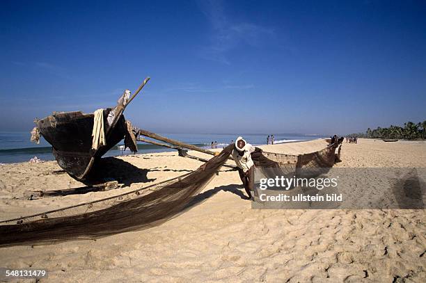 India Goa - fisherman at the beach with a net spreading out to dry - undatiert