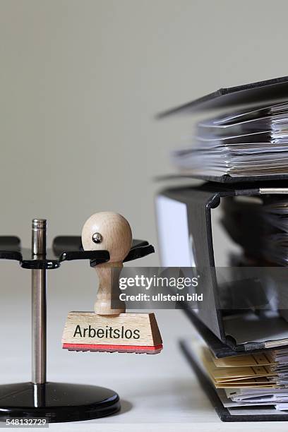 Germany - Stamp with inscription - Arbeitslos - next to a pile of files