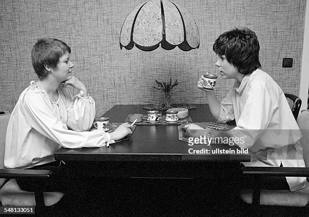 People, two young women sitting at the table drinking coffee and smoking a cigarette, coffee klatch, blouse, aged 23 to 30 years, Monika, Gaby, Gabi -
