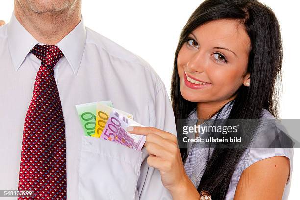 Young woman is pulling cash out of the pocket of a man -