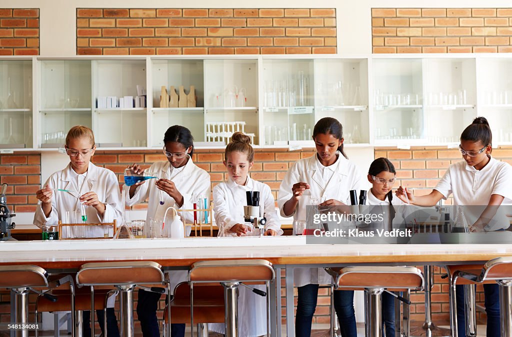 Schoolgirls doing science experiments with liquids