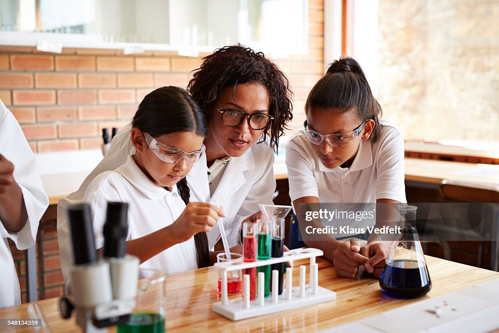 Teacher assisting students with science project
