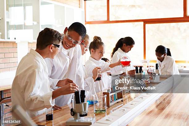 students laughing while doing science projects - chemische reaktion stock-fotos und bilder