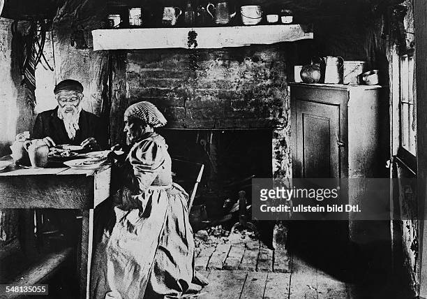 Old Afro-American couple in poor housing conditions having a meal - 1907 - Vintage property of ullstein bild