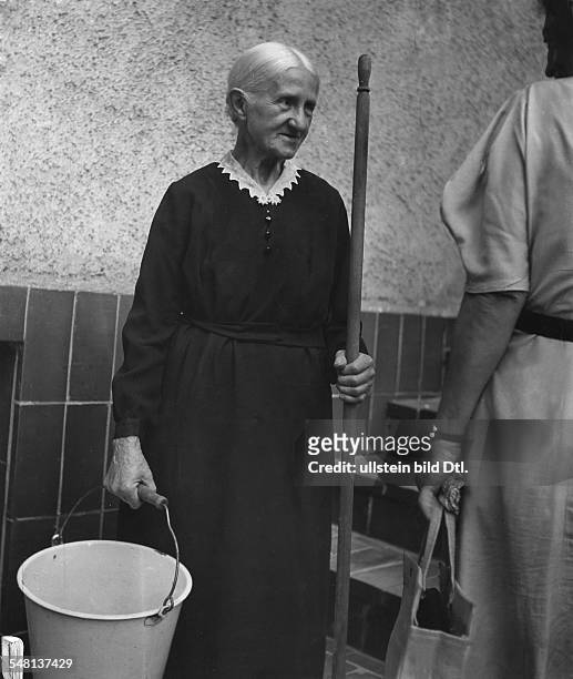 Old woman with bucket and broomstick who works as janitor or caretaker - 1942 - Photographer: Regine Relang - Vintage property of ullstein bild