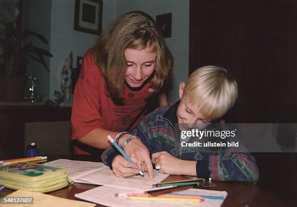 Mädchen hilft ihrem Bruder bei den Schulaufgaben - 1995