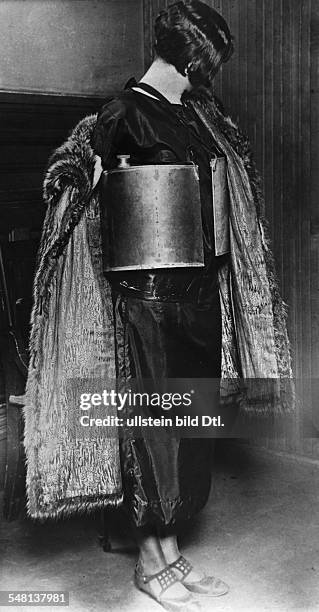 Era of Prohibition Tricks of an alcohol smuggler: woman carrying containers with liquer under her clothes that fit the shape of her body - 1926 -...