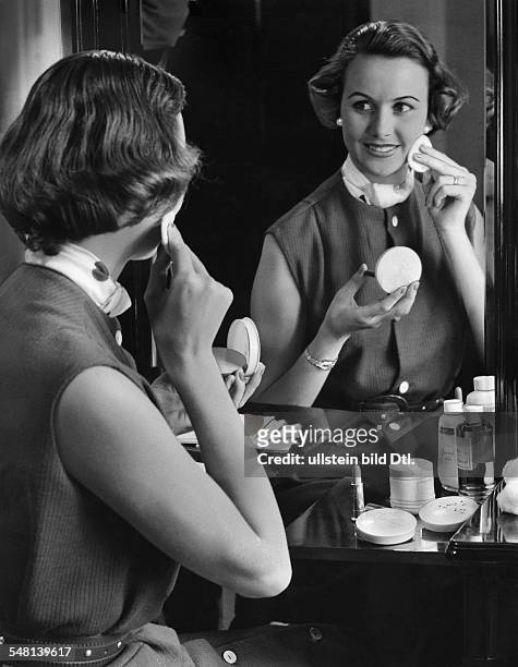 Woman putting on makeup in front of the mirror - 1961 - Vintage property of ullstein bild