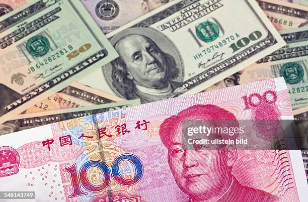 Chinese Yuan Renminbi and Dollar banknotes with portraits of Mao Zedong and Benjamin Franklin