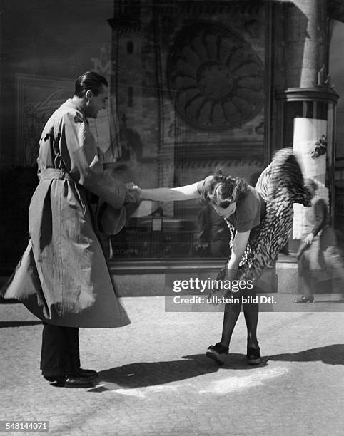 Young woman trying to hold her wind-blown skirt knee-down - 1942 - Photographer: Regine Relang - Vintage property of ullstein bild