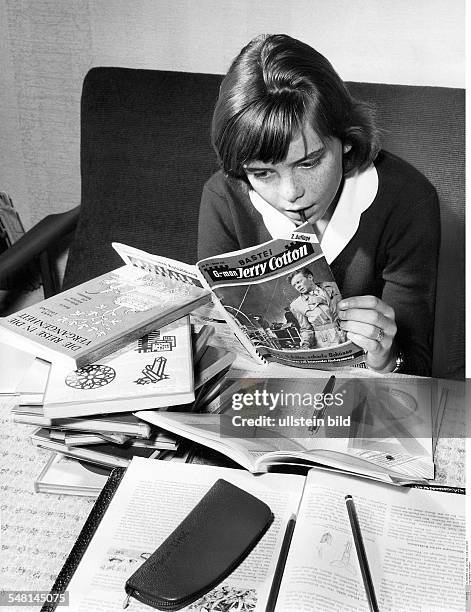 Junges Mädchen macht Pause von den Hausaufgaben, sie schmökert im Jerry-Cotton-Heft - Fotografie: Hugo Schmidt-Luchs