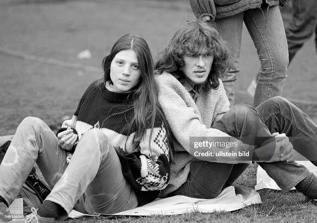 People, young couple sit back to back on a lawn, aged 17 to 20 years - 04.04.1983