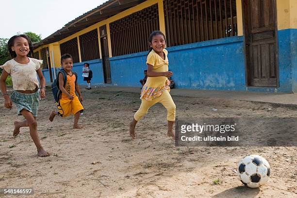 Ecuador Curaray - A village without any road connection in the rainforest of the Oriente, 150 km east of Puyo. Kids playing soccer in the schoolyard...