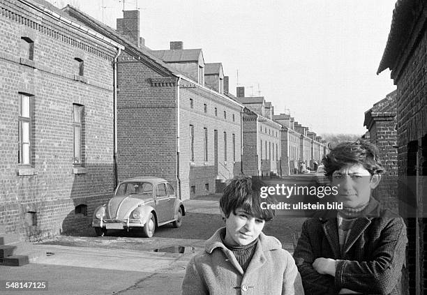 People, children, two boys posing at a housing estate, pithead buildings, colony Eisenheim, in front of a house stands a car, VW, Volkswagen, Beetle,...
