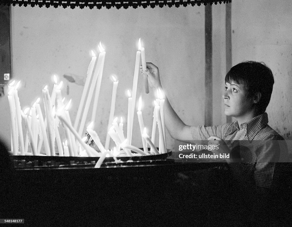 People, death, mourning, remembrance, memorization, young woman lights an offering candle in a church, aged 20 to 30 years, Monika, Spain, Valencia - 15.08.1977