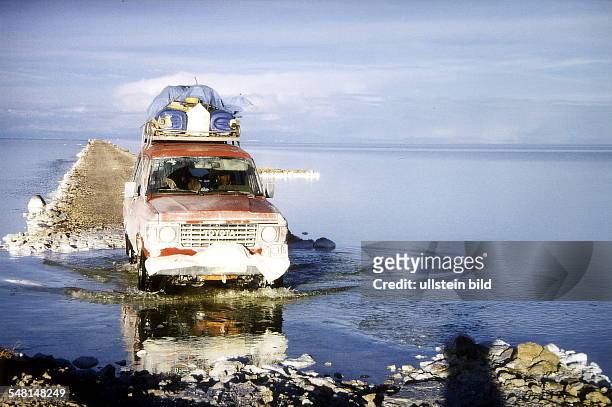Auto unterwegs auf einer schmalen Strasse in der Salzwüste "Salar de Uyuni" im Hochland - Januar 2000